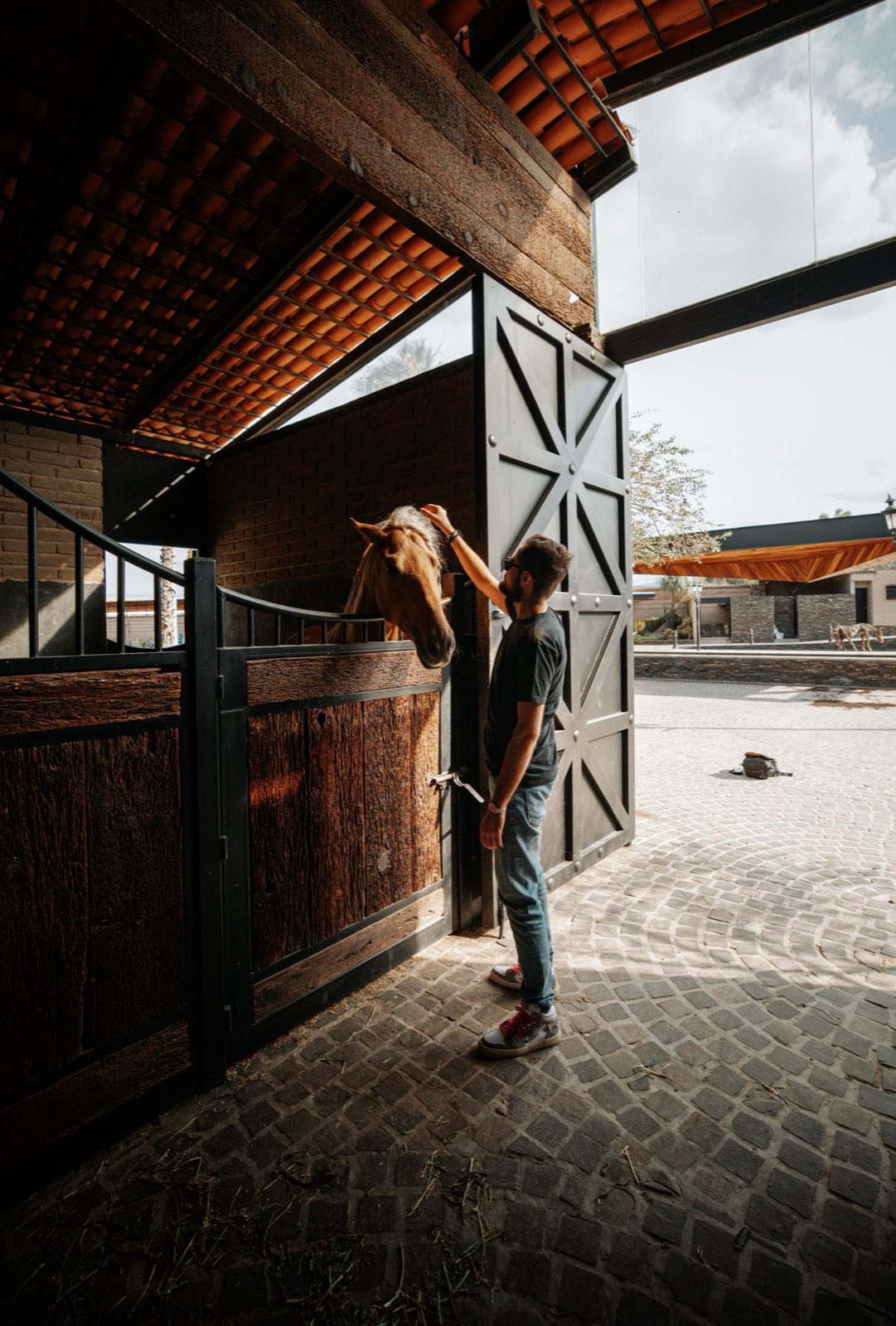 Jinete acariciando a su caballo en las instalaciones de un club hípico